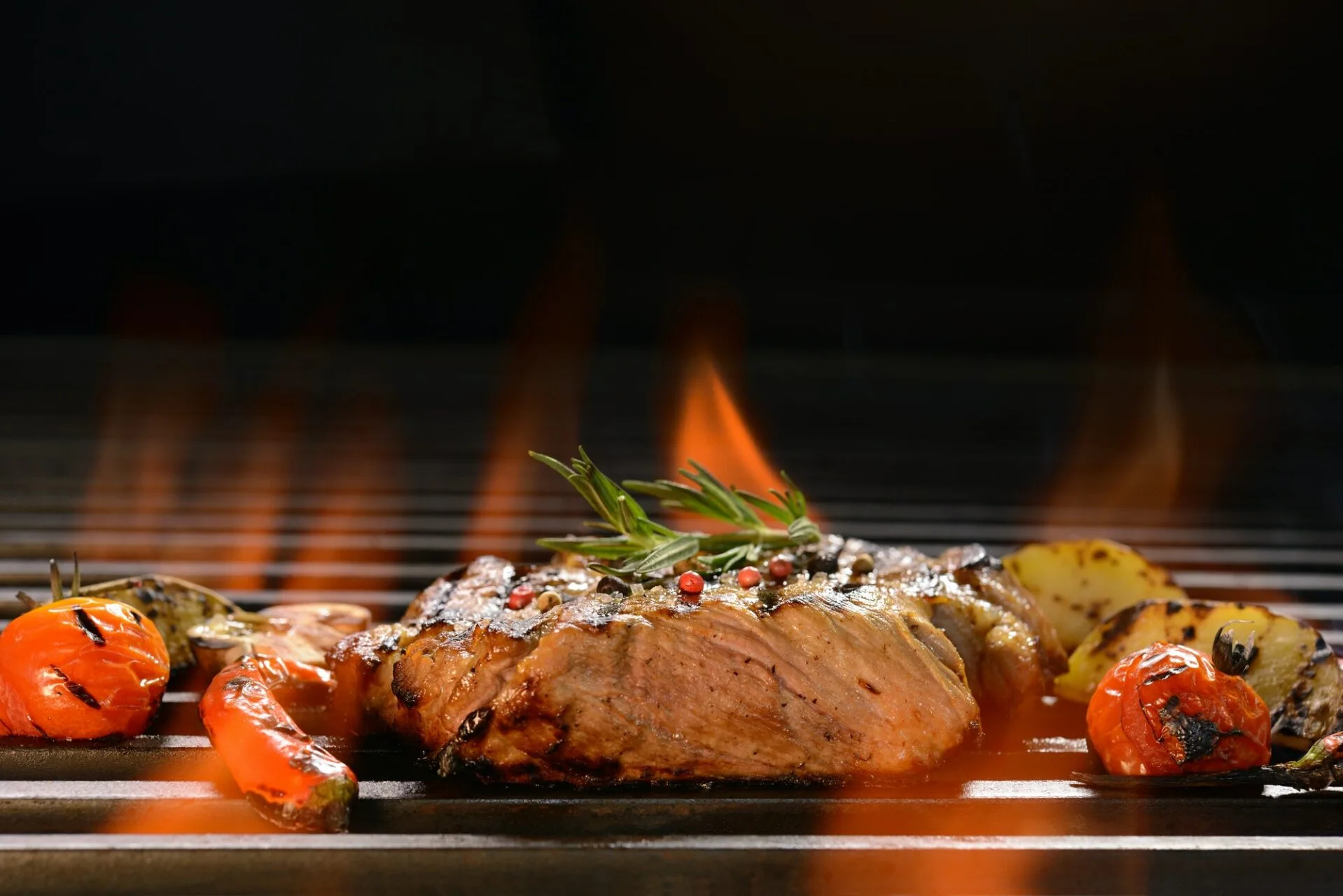Grilled pork steak with vegetable on the flaming grill