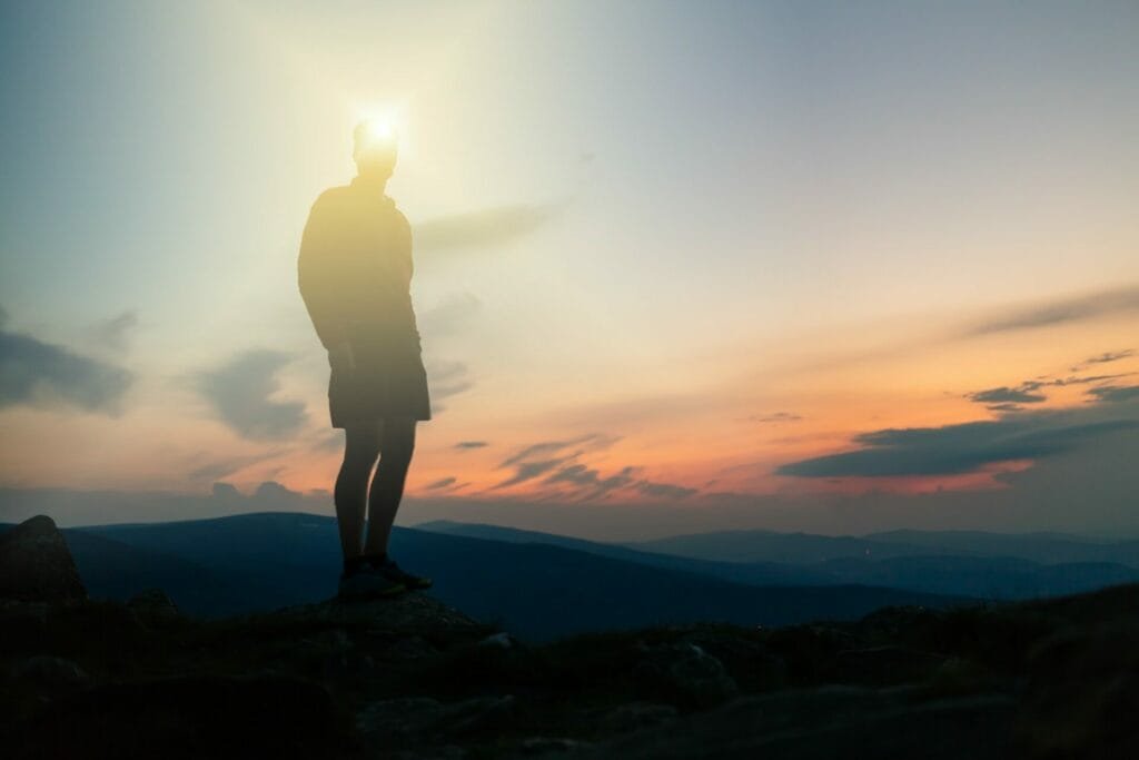 Camping-Stirnlampen: Die besten Optionen im Vergleich 8 Man celebrating sunset looking at view in mountains