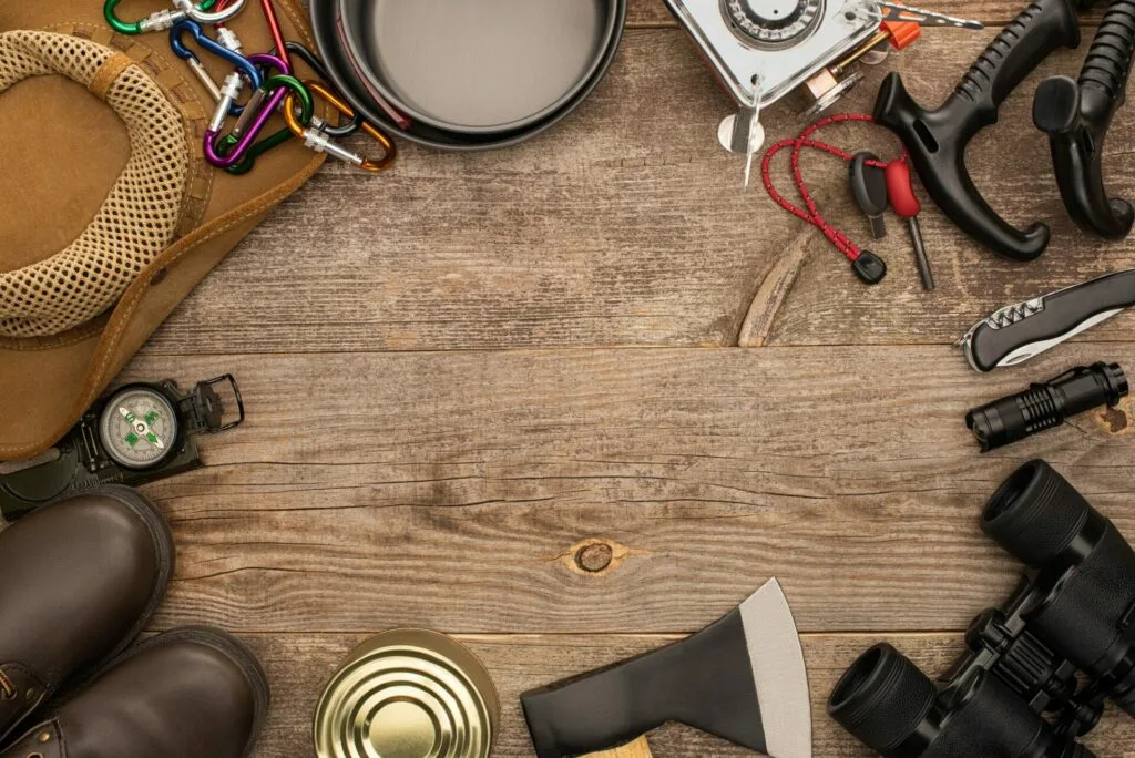 top view of camping equipment on wooden table with copy space