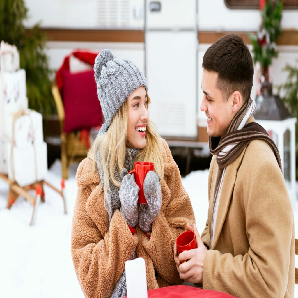 Christmas Picnic. Romantic Couple Enjoying Winter Camping, Drinking Hot Chocolate Outdoors