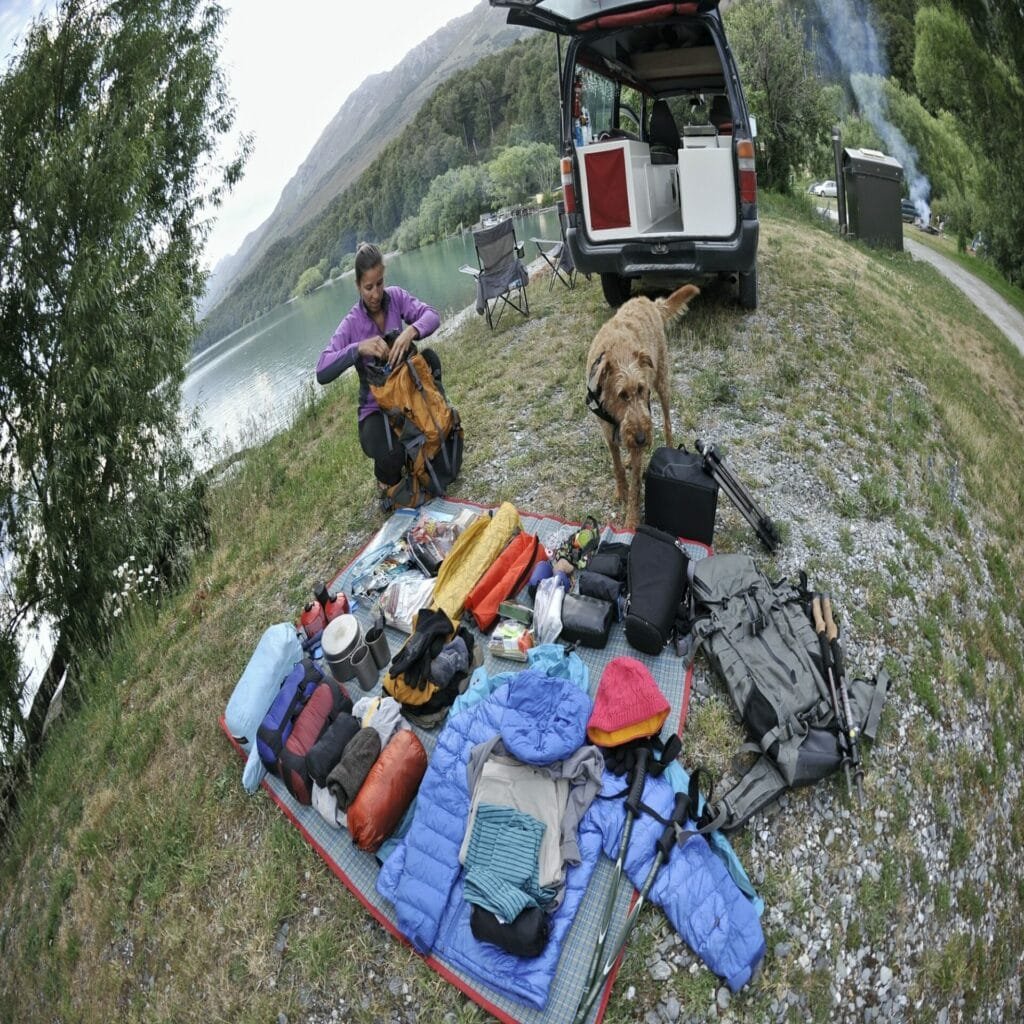 mid adult woman organising camping equipment new zealand - Camping Check