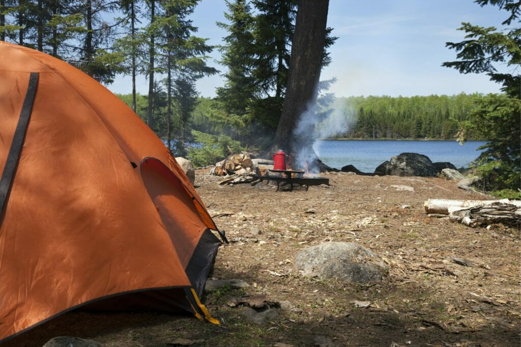 Campsite in northern Minnesota with orange tent and campfire