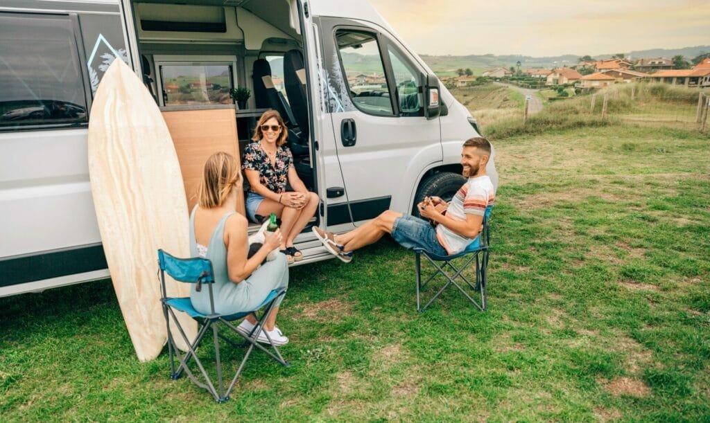 Campervan 1 Friends with their dog talking and drinking beer in front of their camper van