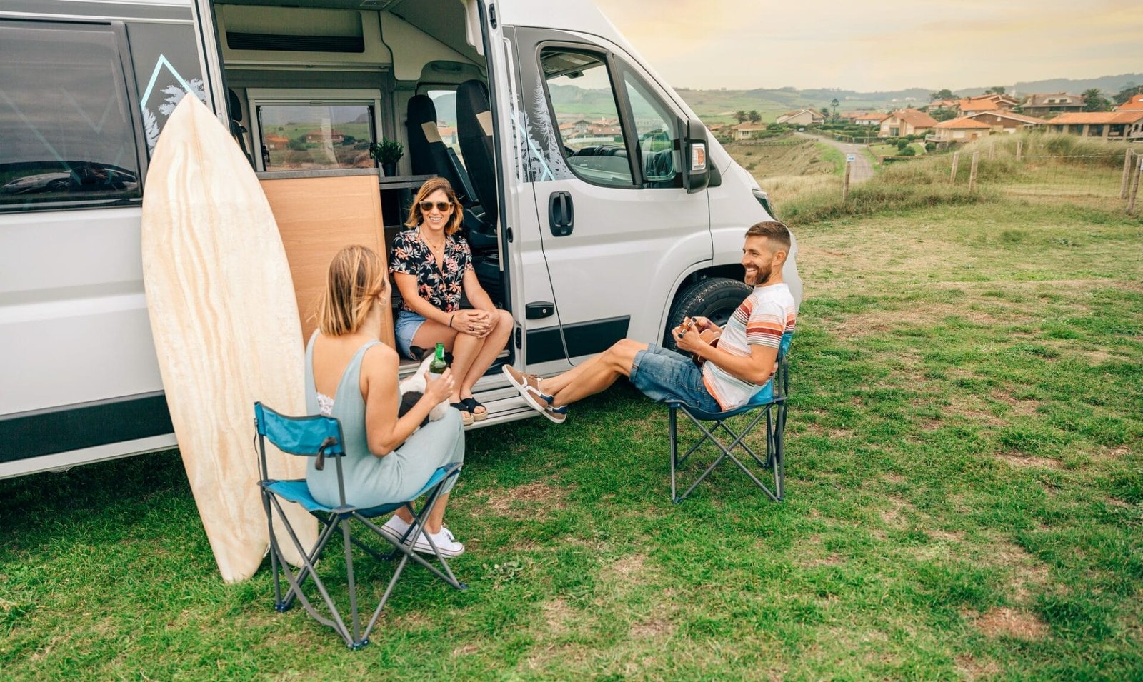 Was ist Campingtourismus? Eine Einführung in die Welt des Campings 5 Friends with their dog talking and drinking beer in front of their camper van