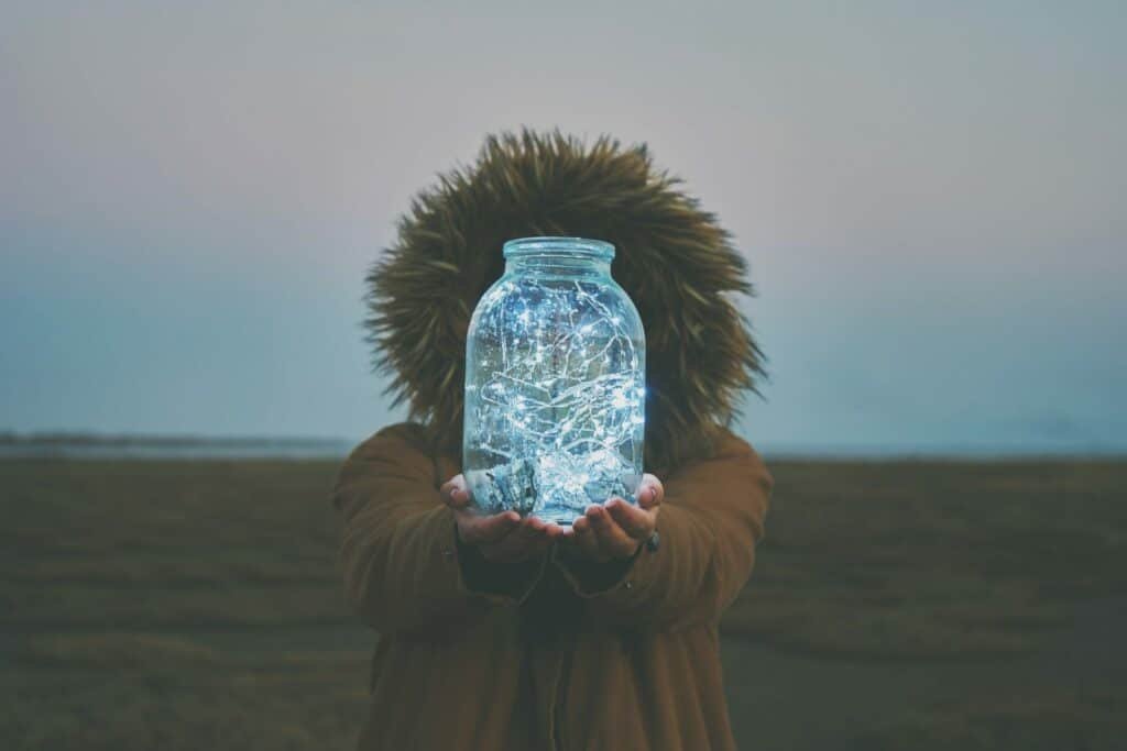 Campinglaterne: Der ultimative Leitfaden zur Auswahl der perfekten Laterne 6 Girl is holding fairy lights in a jar on winter dry landscape
