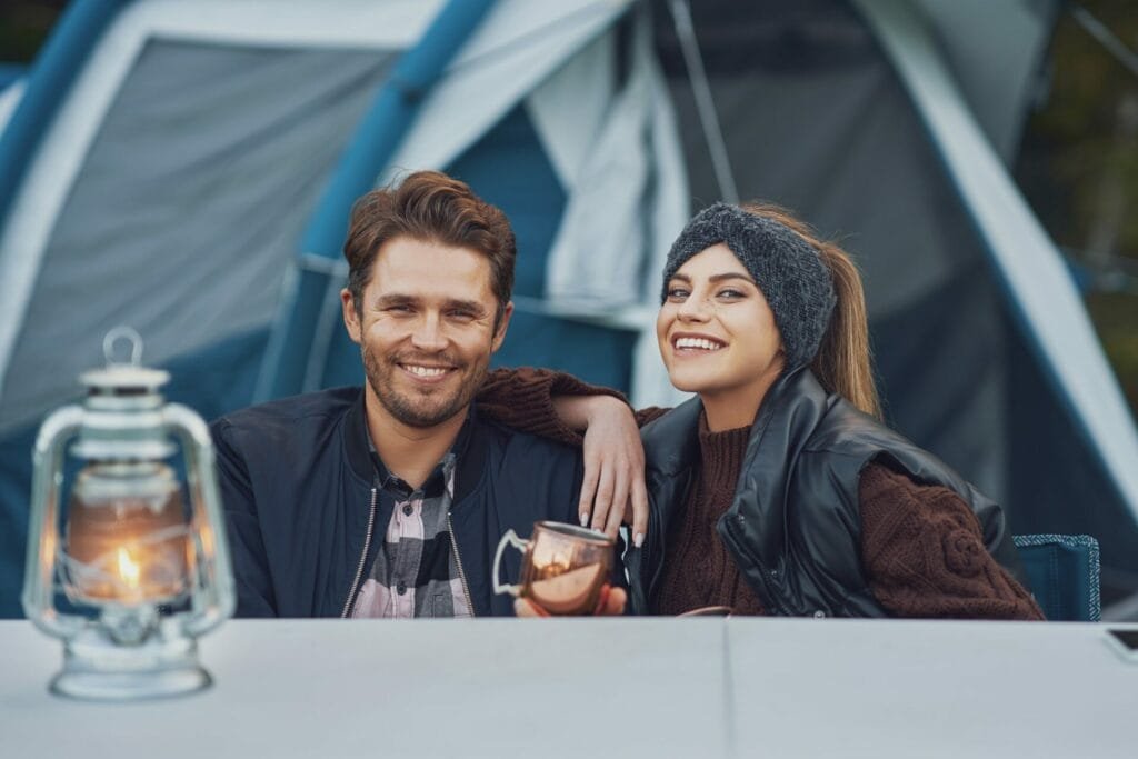 Campinglaterne: Der ultimative Leitfaden zur Auswahl der perfekten Laterne 4 Young nice couple having fun on camping with kerosene lamp