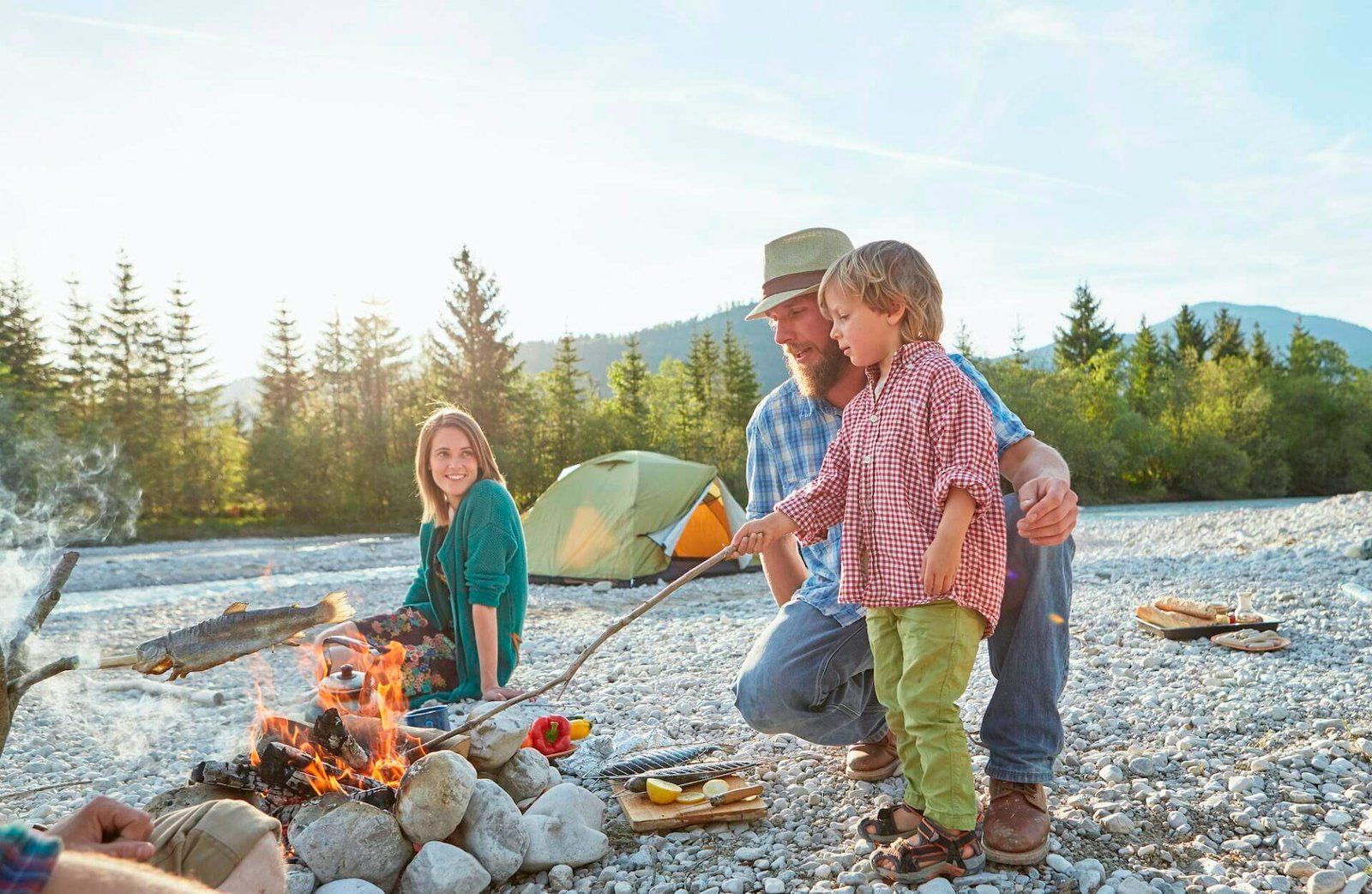 Was ist Campingtourismus? Eine Einführung in die Welt des Campings 4 Boy and mid adult man poking campfire with branch