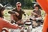 Caucasian man frying eggs on burner at camping