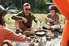 Caucasian man frying eggs on burner at camping
