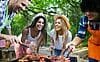 Happy friends camping and having a barbecue in nature