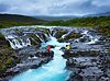 Travelers on Bruarfoss waterfall, Iceland. Famouns place in Iceland. Fast river and cascades.