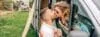 Couple kissing through the camper van window during a trip