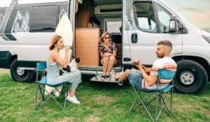 Campingabenteuer pur: Ihr ultimativer Guide für einen unvergesslichen Campingurlaub 3 Friends with their dog drinking beer in front of their camper van