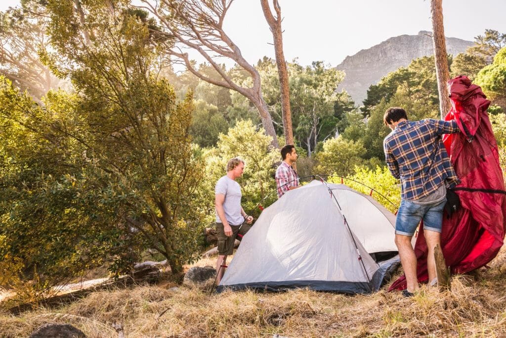 Kuppelzelte: Alles, was Sie wissen müssen 2 Three men putting up dome tent in forest, Deer Park, Cape Town, South Africa