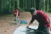 A father and son building a tent at a campsite.