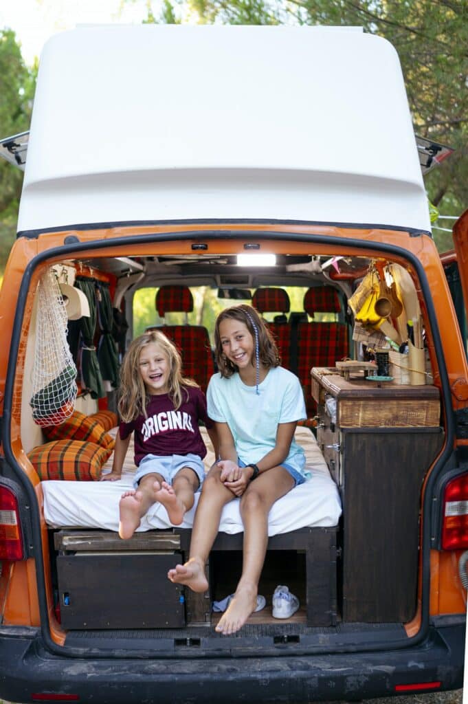 Happy children take a self on a wonderful day at camp. Van life concept.