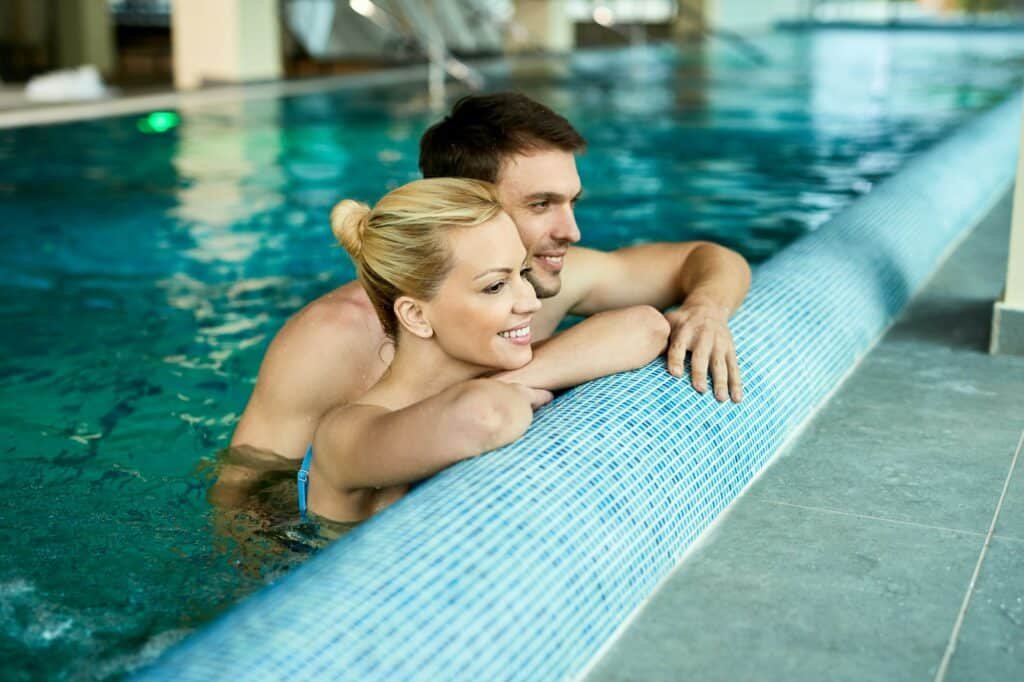 Happy couple enjoying in swimming pool at the spa.