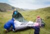 family gathers tent in mountains on hike. outdoor activities for children and elderly