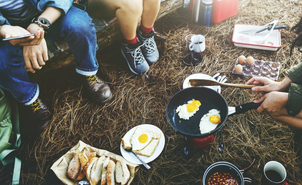 Group of friends camping together cooking food