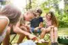 Teenagers camping, cooking vegetables on barbecue grill.