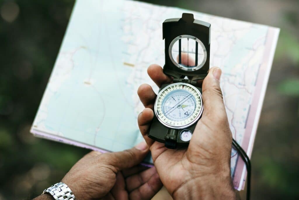 Hand holding compass and a map