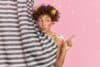Lovely African American woman keeps lips folded takes morning shower in bathroom undergoes self care
