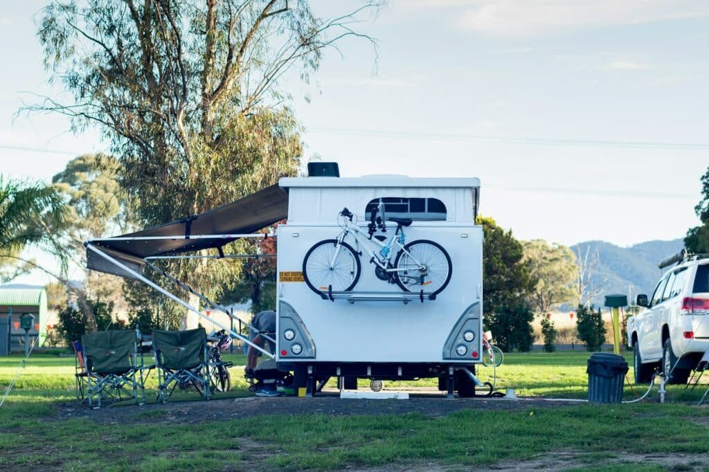 Der ultimative Guide zum Caravaning: Tipps für unvergessliche Reisen 2 RV caravan with bike on the back camping at the caravan park