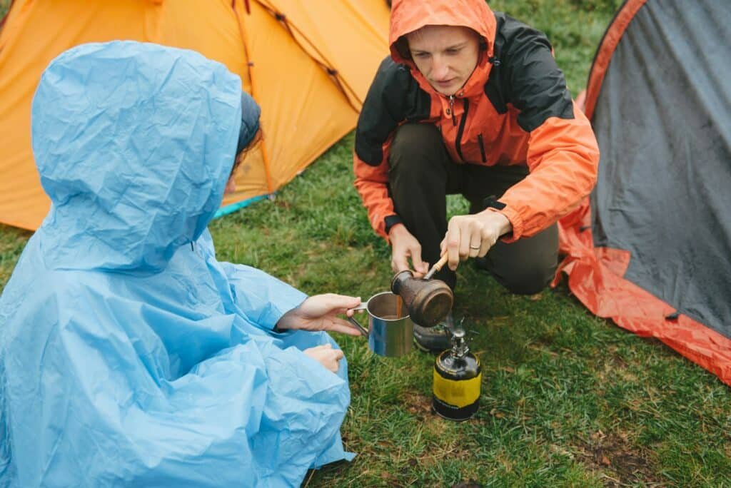 Zelt: Welche Wassersäule ist die Richtige? 1 Travelers cooking near tents in rainy mountains