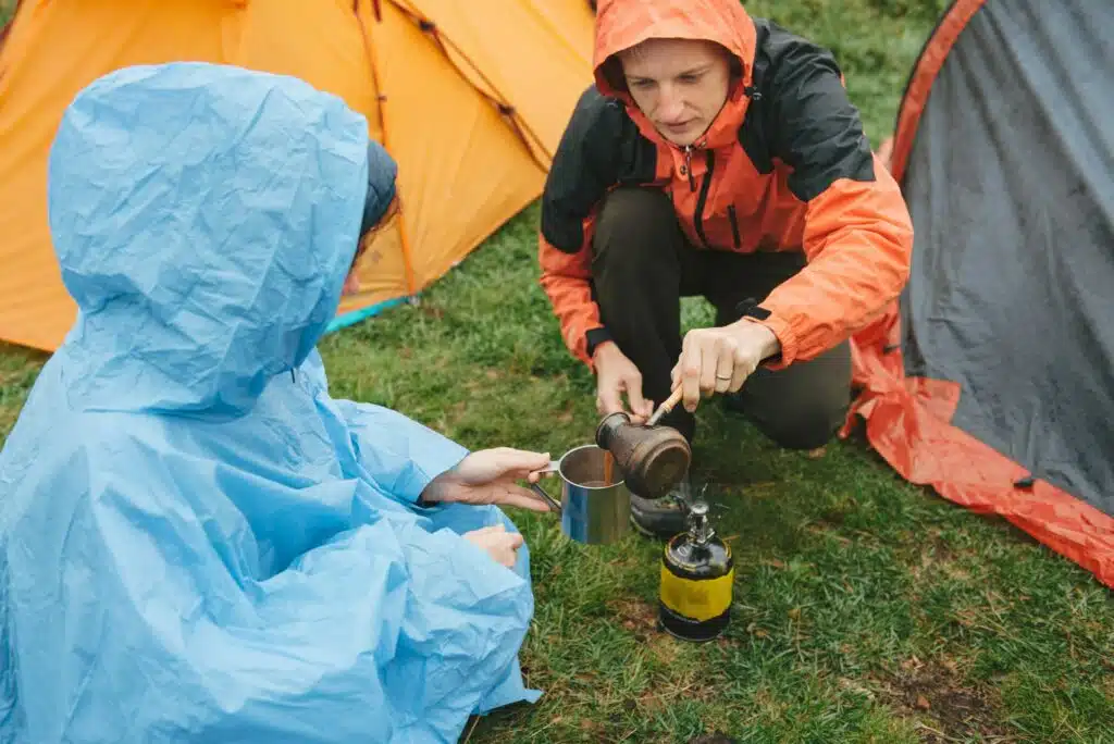 Zelt: Welche Wassersäule ist die Richtige? 1 Travelers cooking near tents in rainy mountains