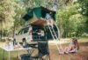 Woman in tent over 4x4 and other putting hiking boots