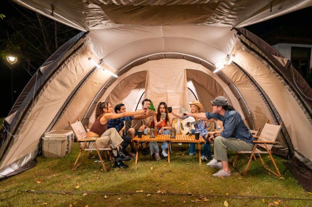 Schnellaufbau Zelt gesucht? So findest du dein Traumzelt für entspannte Campingmomente 3 Group of diverse friend having outdoors camping party together in tent.