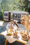 Beautiful wedding couple laugh and kiss relaxing in rv, camping in a trailer. Romantic moment.
