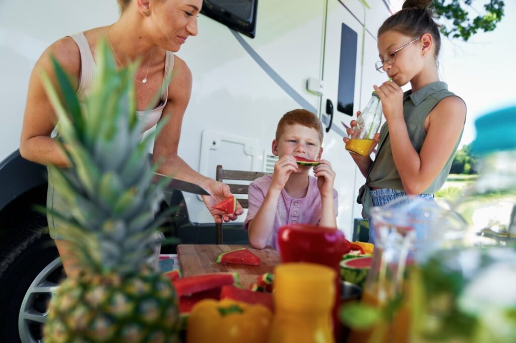 Veganer Campingführer für Familien: 12 Tipps für den perfekten pflanzlichen Outdoor-Trip 4 Children eating snacks while camper camping