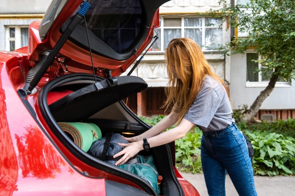 Amazon Basics Kuppelzelt 3-Jahreszeiten-Zelt: Dein zuverlässiger Begleiter für unvergessliche Outdoor-Abenteuer 1 Young woman putting luggage for camping in car