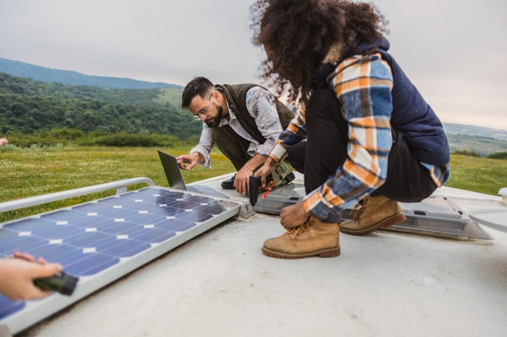 Stromverbrauch & Batterielaufzeit: Der ultimative Camping-Ratgeber für autarke Outdoor-Abenteuer 1 Friends setting up solar panels on an RV roof during camping trip