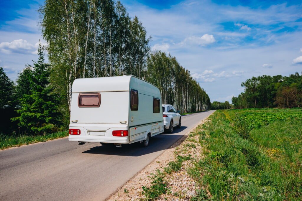 Die besten Tipps für unvergessliche Ferien Camping Erlebnisse 2 White caravan driving road on the way to the vacations. Beautiful camping holidays with camping car