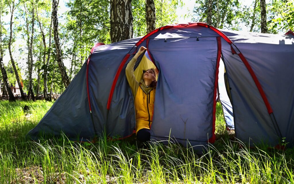 Troubleshooting-Guide #1: Zelt undicht - Schnelle Hilfe bei Wasserschäden 2 a girl in a yellow raincoat sets up a blue tent for camping in the forest, living in nature, prepari