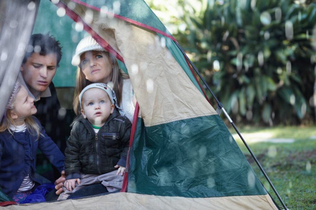 Troubleshooting-Guide #1: Zelt undicht - Schnelle Hilfe bei Wasserschäden 1 Oh no, its raining. Young family stuck in their tent during a rainy day.