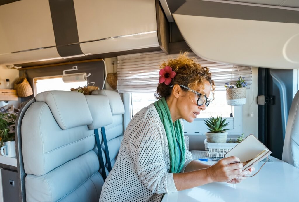 Top Auswahl: Freistehendes Vorzelt mit Rückwand für perfekten Komfort 4 One woman reading a book or writes and plans sitting inside a camper van motorhome